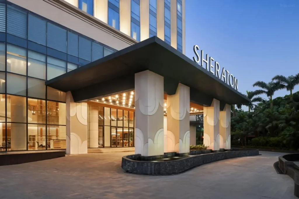 The entrance at dusk, with the canopy and the SHERATON sign lit up (Photo: Trip.com)