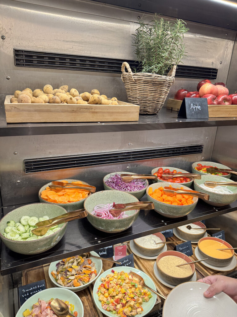 Salad bar with labeled vegetables and dressings