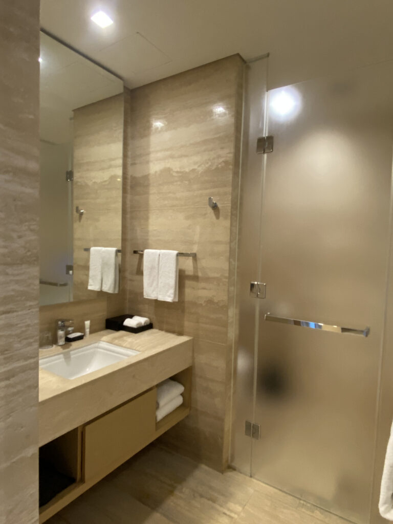 The marble bathroom sink. Large mirror and folded towels