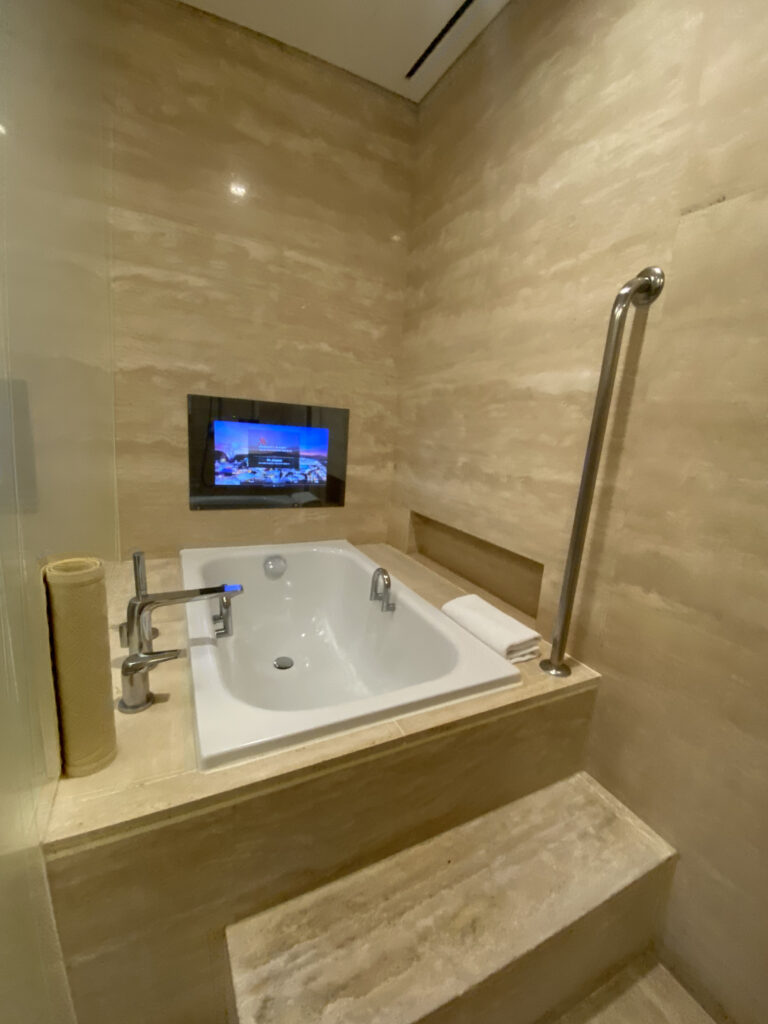 The bathtub, and the TV mounted right in front of it. The screen reads MARRIOTT'S RESORT