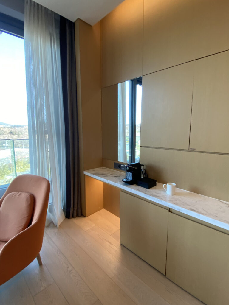 The minibar corner with a Nespresso machine, tea bags, and wine glasses
