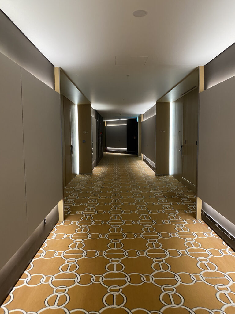 The corridor with its yellow patterned carpet. Room 1612, excitement building before the door opens