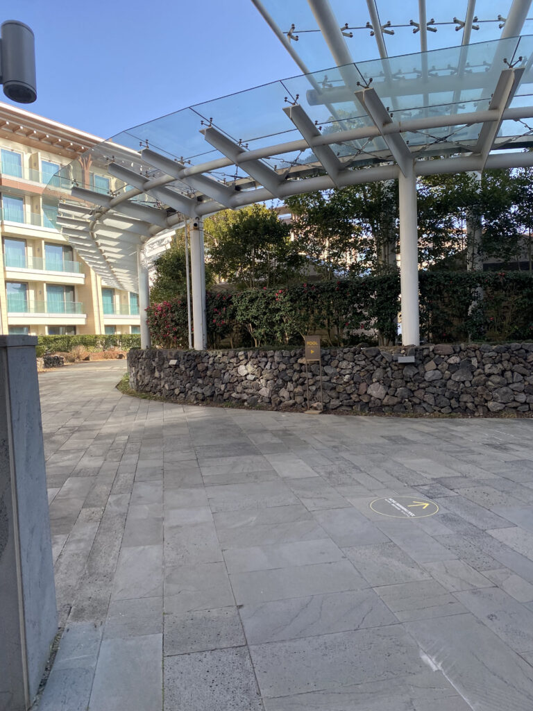 The hotel entrance. Stone wall and glass canopy