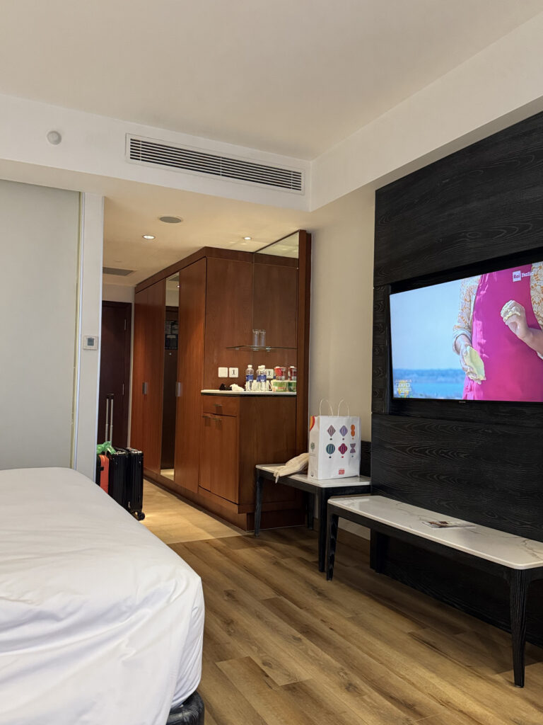 The standard room. Bed, TV, wardrobe, and the minibar corner all in one glance